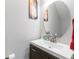 Bathroom featuring a modern vanity, oval mirror, and minimalist decor with a red towel at 5351 Paramount View Way, Sugar Hill, GA 30518
