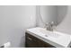 Stylish powder room featuring a modern vanity with a sink and a sleek, round mirror at 5351 Paramount View Way, Sugar Hill, GA 30518
