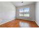 View of the bedroom featuring hardwood floors, neutral walls, and a window with blinds at 5351 Paramount View Way, Sugar Hill, GA 30518