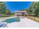 Backyard view of in-ground pool and two-story home with covered porch at 664 Johnson Rd, Oxford, GA 30054