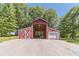 View of the red barn with large doors and a white garage door attached at 664 Johnson Rd, Oxford, GA 30054