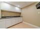 Basement kitchenette with white cabinets, double sink and light wood flooring at 664 Johnson Rd, Oxford, GA 30054