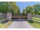 View of the gated entrance to the property, featuring stone pillars and a black metal gate at 664 Johnson Rd, Oxford, GA 30054