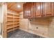 Functional laundry room with shelving, cabinets, and wood paneled walls at 664 Johnson Rd, Oxford, GA 30054
