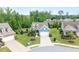 Aerial view of a charming blue home with lush green landscaping in a tranquil suburban neighborhood at 7430 Ramsgate Ct, Cumming, GA 30040