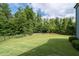 Large, private backyard featuring a lush lawn and a tree-lined perimeter, perfect for outdoor activities at 7430 Ramsgate Ct, Cumming, GA 30040