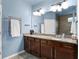 Bright bathroom with double sinks, granite countertops, and a modern towel warmer at 7430 Ramsgate Ct, Cumming, GA 30040