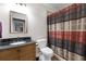 Nicely appointed bathroom with granite counters, wood cabinets, and shower with curtain at 7430 Ramsgate Ct, Cumming, GA 30040