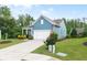 Charming blue home featuring a manicured lawn and driveway leading to a two-car garage with curb appeal at 7430 Ramsgate Ct, Cumming, GA 30040