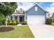 Charming blue home with a well-maintained lawn, landscaping, and a two-car garage, offering great curb appeal at 7430 Ramsgate Ct, Cumming, GA 30040