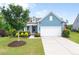 Beautiful blue home with a manicured lawn, colorful landscaping, and an attached two-car garage at 7430 Ramsgate Ct, Cumming, GA 30040