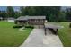 Aerial view of a two-story brick home with a two-car garage, covered parking, and a well-manicured lawn at 125 Pebble Beach Ct, Atlanta, GA 30349
