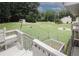Backyard view from a deck, featuring lush green grass, a fence, and mature trees at 125 Pebble Beach Ct, Atlanta, GA 30349