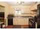 Traditional kitchen featuring stainless steel sink and black appliances with light wood cabinetry at 125 Pebble Beach Ct, Atlanta, GA 30349