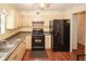 Traditional kitchen featuring black appliances with light wood cabinetry, and wood flooring at 125 Pebble Beach Ct, Atlanta, GA 30349