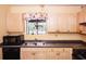Traditional kitchen featuring stainless steel sink, and black appliances with light wood cabinetry at 125 Pebble Beach Ct, Atlanta, GA 30349