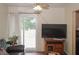 Bright living room with a sliding glass door, wood floors and large TV at 125 Pebble Beach Ct, Atlanta, GA 30349