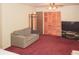 Bedroom featuring a sitting area with a sofa, plush red carpet, and closet storage at 125 Pebble Beach Ct, Atlanta, GA 30349