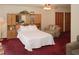 Spacious main bedroom with a king bed, built-in cabinets, comfortable seating, and plush red carpet at 125 Pebble Beach Ct, Atlanta, GA 30349