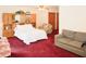 Main bedroom with king bed, built-in storage, comfy chair, sofa, and plush red carpet at 125 Pebble Beach Ct, Atlanta, GA 30349