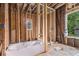 The under-construction bathroom showcases new framing, a modern tub, and a window, ready for personalized finishes and a spa-like atmosphere at 1406 Allene Sw Ave, Atlanta, GA 30310