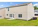 View of the home's exterior features a well-maintained lawn and neutral-toned siding at 1560 Avalon Creek Rd, Sugar Hill, GA 30518