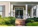 Inviting front entrance with brick steps, gray double doors, and stylish columns at 6186 Talmadge Nw Run, Acworth, GA 30101