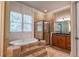 Main bathroom has a tub with steps, glass enclosed shower, and nice vanity lighting at 6186 Talmadge Nw Run, Acworth, GA 30101