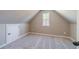 Finished attic with carpet, a window, and a door to additional storage space at 1500 Alcovy Station Rd, Covington, GA 30014