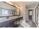Bathroom with double sink vanity, large mirror, wood floors, and shower with glass door at 1500 Alcovy Station Rd, Covington, GA 30014