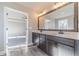 Bathroom with double sink vanity, large mirror, wood floors, and view to the Primary bedroom at 1500 Alcovy Station Rd, Covington, GA 30014