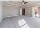 Spacious bedroom with tray ceilings, ceiling fan, carpet, and doors to other rooms at 1500 Alcovy Station Rd, Covington, GA 30014