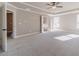 Large bedroom with neutral walls, carpet flooring, fan, and doors leading to en suite bathroom at 1500 Alcovy Station Rd, Covington, GA 30014
