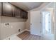 Well-lit laundry room featuring dark wood cabinetry, wood-look flooring and access to another room at 1500 Alcovy Station Rd, Covington, GA 30014