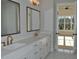 Elegant bathroom with double vanity, gold fixtures, and a doorway view of a sunlit bedroom at 1670 Knob Creek Nw Ct, Acworth, GA 30101