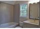 Well-lit bathroom with a large mirror, single sink vanity, gray tile and natural light from the window at 1670 Knob Creek Nw Ct, Acworth, GA 30101