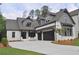 Beautiful home featuring white brick, a dark gray roof, a three car garage and mature landscaping at 1670 Knob Creek Nw Ct, Acworth, GA 30101