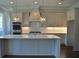 Modern kitchen with stainless steel appliances, an island, and stylish pendant lighting at 1670 Knob Creek Nw Ct, Acworth, GA 30101