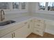 Bright laundry room features white cabinetry, quartz countertops and a brushed gold faucet at 1670 Knob Creek Nw Ct, Acworth, GA 30101