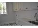Bright laundry room with stylish star-patterned tile floor and custom white cabinets for ample storage at 1670 Knob Creek Nw Ct, Acworth, GA 30101