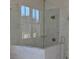 Modern shower featuring a glass enclosure, white marble tile, and gold fixtures, offering a luxurious experience at 1670 Knob Creek Nw Ct, Acworth, GA 30101