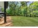 Expansive backyard space with lush green lawn, bordered by mature trees and a wood fence at 1690 Eaglecreek Trl, Cumming, GA 30041