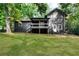 View of backyard featuring manicured lawn, back deck and black siding at 1690 Eaglecreek Trl, Cumming, GA 30041
