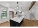 Open-concept kitchen boasts a black island with stainless sink and staircase access at 1690 Eaglecreek Trl, Cumming, GA 30041