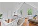 Bedroom with hardwood floors, pitched ceiling, and white railing overlooking a seating area at 343 Josephine Ne St, Atlanta, GA 30307