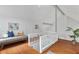 Sunlit bedroom with hardwood floors, pitched ceiling, and white railing overlooking the space at 343 Josephine Ne St, Atlanta, GA 30307