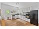 Eat-in kitchen featuring white cabinets, stainless steel appliances, hardwood floors, and a door to the backyard at 343 Josephine Ne St, Atlanta, GA 30307
