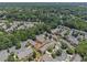 Aerial view of townhome community surrounded by trees, greenery, and winding roads at 401 Wellwood Way, Roswell, GA 30075