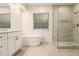 Bright and modern bathroom with a soaking tub and glass enclosed shower at 401 Wellwood Way, Roswell, GA 30075