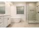 Elegant bathroom featuring double vanity, soaking tub, and glass-enclosed shower with tile surround at 401 Wellwood Way, Roswell, GA 30075